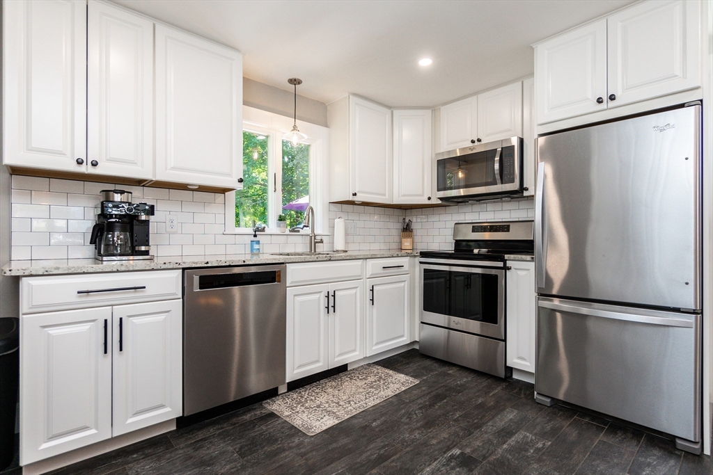 23 Thistledale Road Wakefield, MA 01880 - Photo 10 of 41 a kitchen with white cabinets stainless steel appliances and window