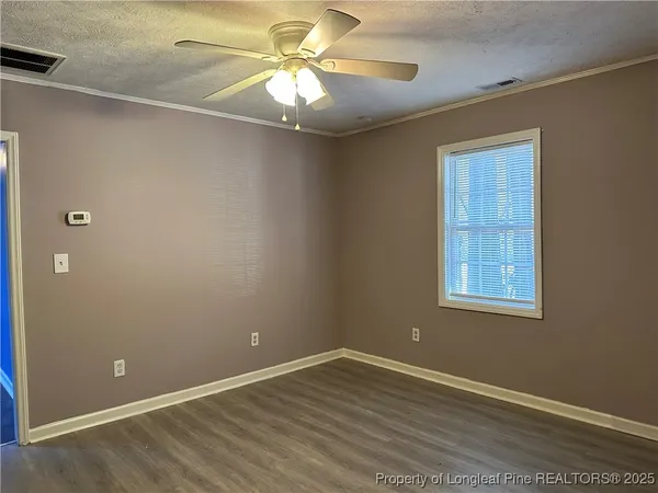 an empty room with a window and a fan