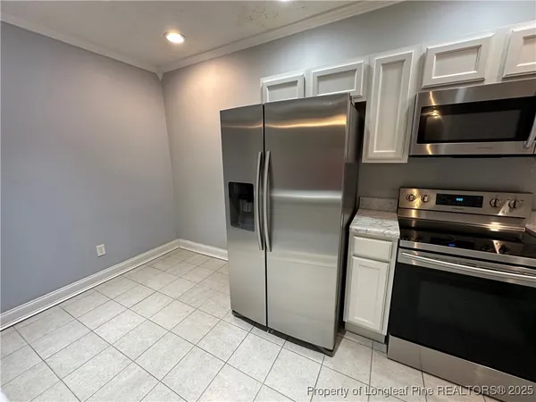 a metallic refrigerator freezer sitting in a kitchen