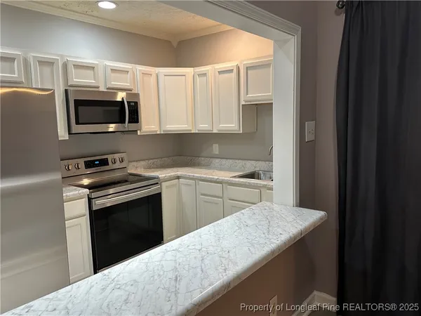 a kitchen with granite countertop a stove top oven and sink