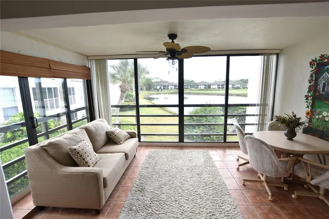 a living room with furniture and a floor to ceiling window