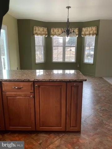 a kitchen with granite countertop wooden cabinets and a granite counter top