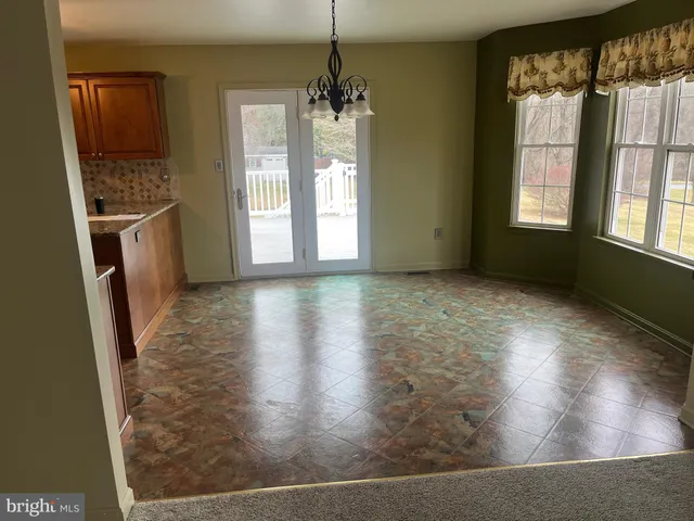 a view of a room with wooden floor and a window