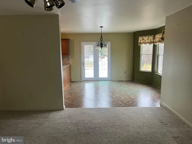 an empty room with windows and chandelier