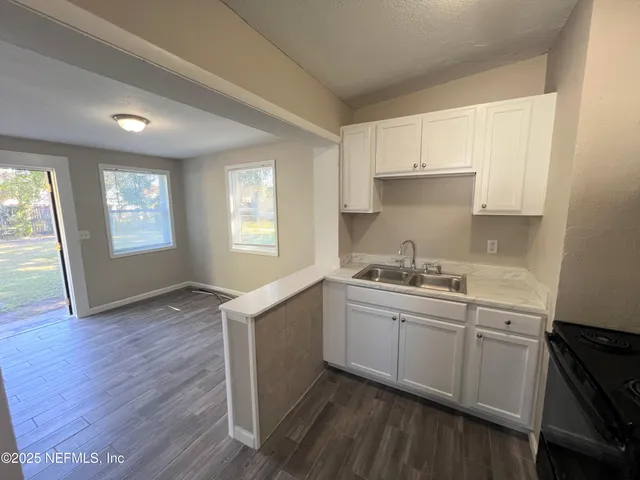 a kitchen with sink cabinets and wooden floor