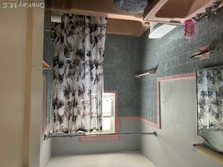 62-53 80th Road Queens, NY 11385 - Photo 10 of 11 Bathroom with tile walls, shower / bathtub combination with curtain, and vanity