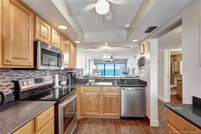 a kitchen with stainless steel appliances granite countertop a sink stove and refrigerator