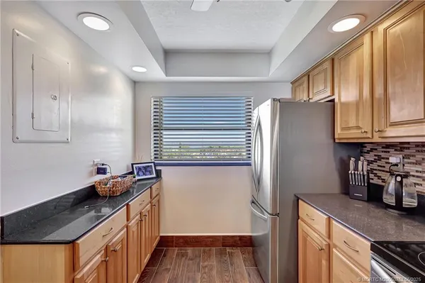 a kitchen with stainless steel appliances granite countertop a refrigerator and a sink