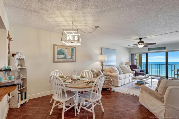 a view of a dining room with furniture a chandelier and wooden floor