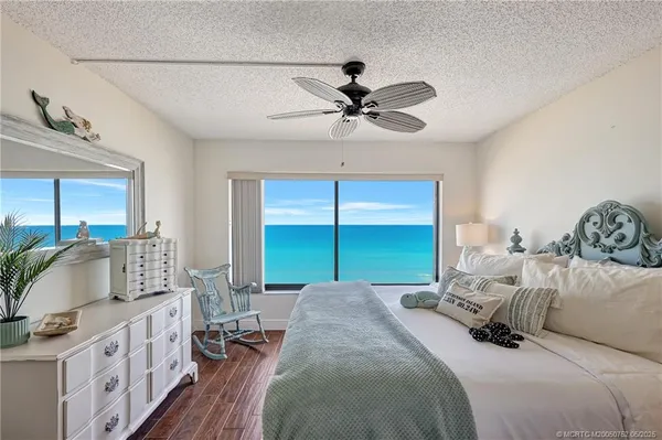 a bedroom with a bed a large window and flat screen tv