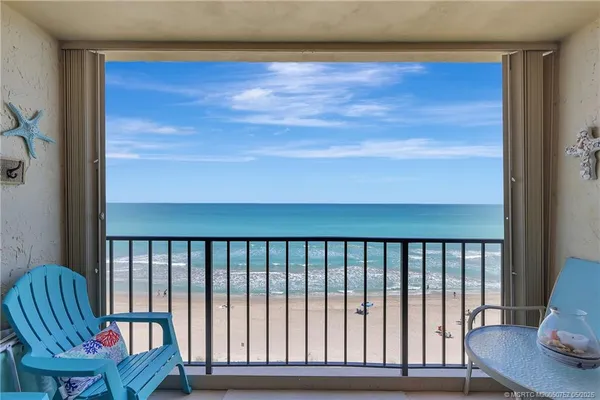 a view of a balcony with chair and wooden floor