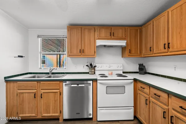 a kitchen with granite countertop a refrigerator stove and cabinets