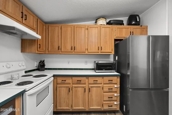 a kitchen with a refrigerator sink and cabinets