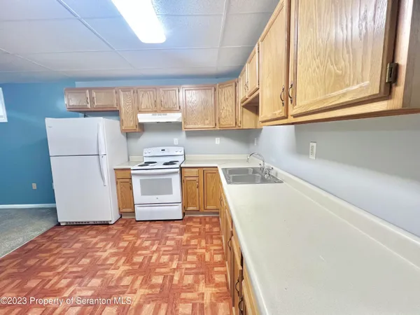 a kitchen with a refrigerator a stove top oven a sink and a window