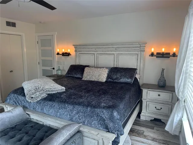 a bedroom with a bed and wooden floor