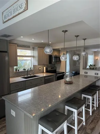 a large kitchen with stainless steel appliances a large counter top