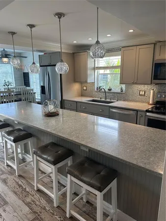 a kitchen with a sink a counter top space cabinets and stainless steel appliances