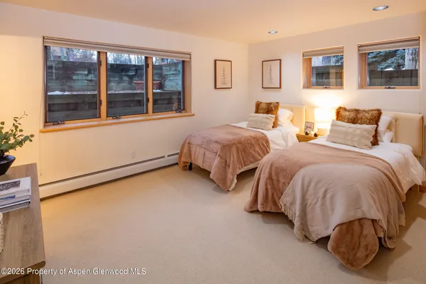 a spacious bedroom with two beds and a window