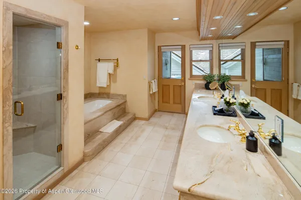 a bathroom with a tub shower and mirror
