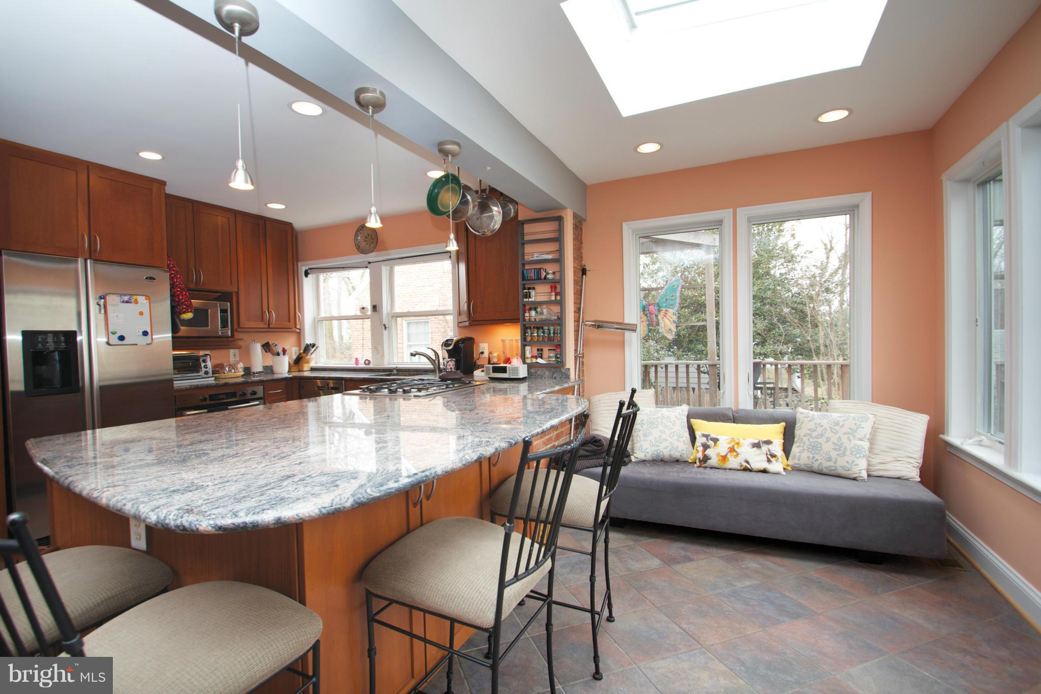 8215 Maple Ridge Road Bethesda, MD 20814 - Photo 3 of 23 a dining room with stainless steel appliances granite countertop a couch a large window and white kitchen