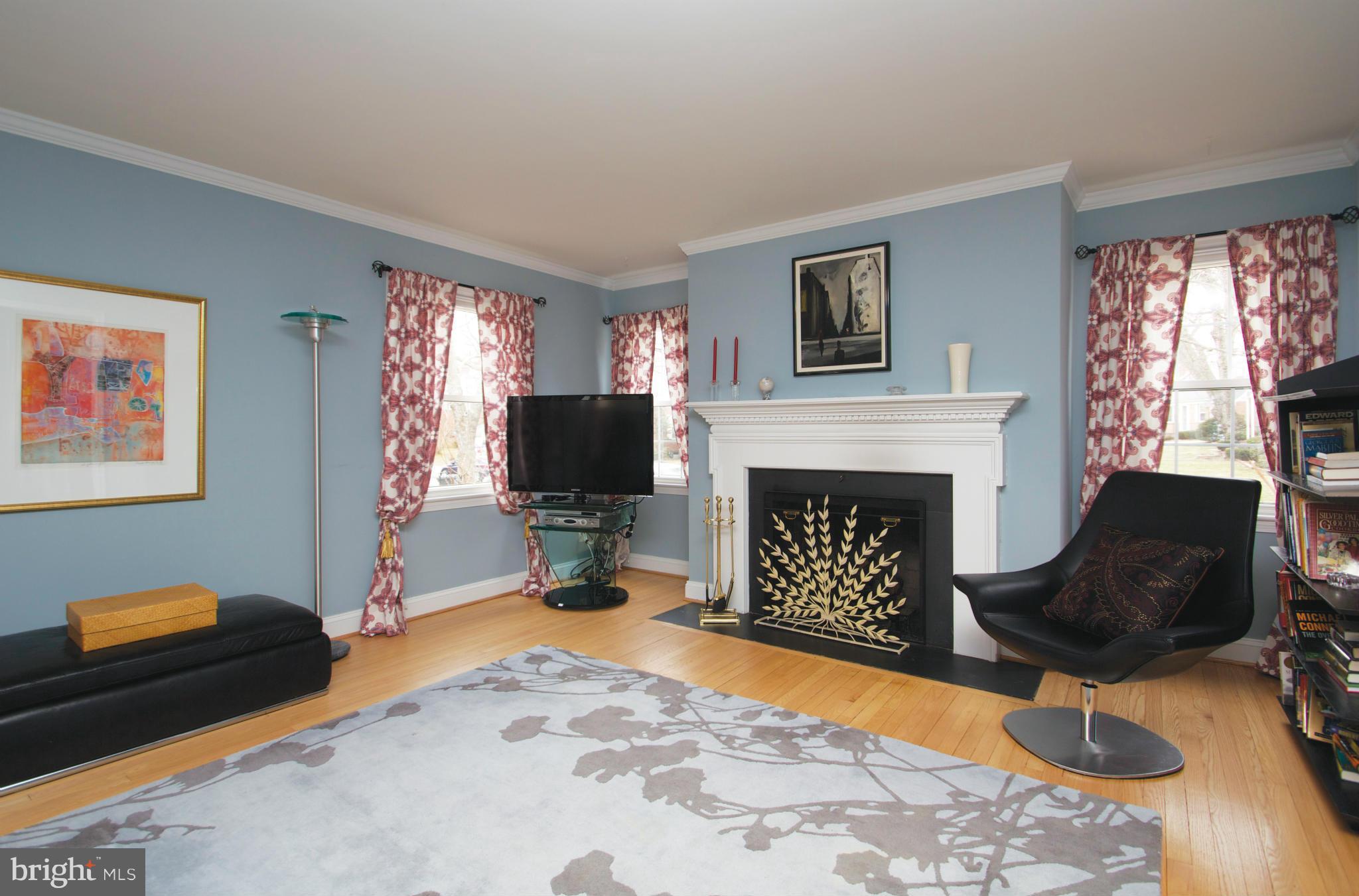 8215 Maple Ridge Road Bethesda, MD 20814 - Photo 8 of 23 a living room with furniture a flat screen tv and a fireplace
