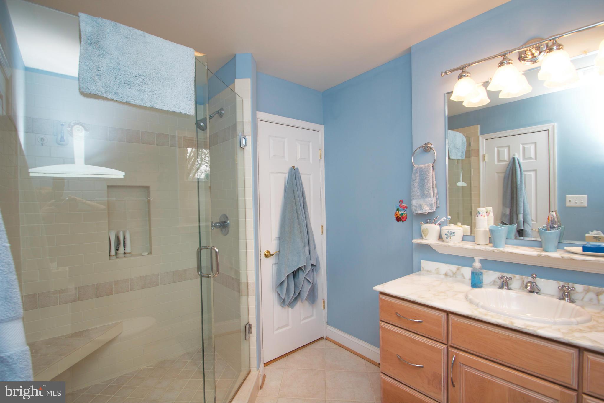 8215 Maple Ridge Road Bethesda, MD 20814 - Photo 10 of 23 a bathroom with a granite countertop sink a shower and a mirror