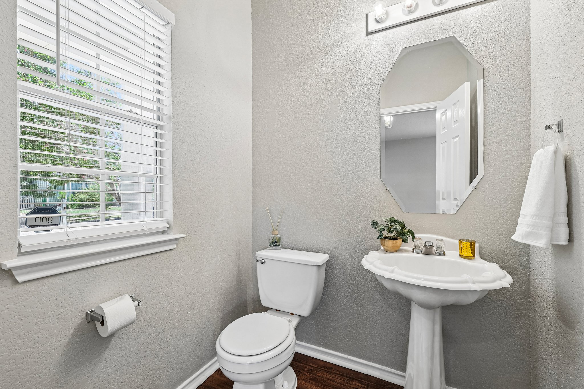 616 Scheel Road Kyle, TX 78640 - Photo 31 of 39 A well-lit half bathroom offers privacy and convenience, with hardwood flooring underfoot.