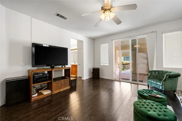 a view of a dining room and livingroom with furniture wooden floor a chandelier