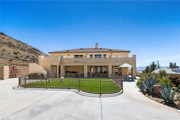 a view of a house with a balcony and yard