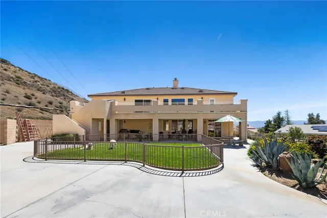 a view of a house with a balcony and yard