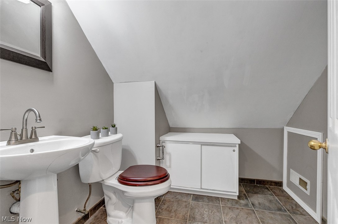 2972 Yorkshire Road Cleveland Heights, OH 44118 - Photo 22 of 44 Pedestal sink with brushed nickel faucet, toilet with wood-finish seat, built-in lower cabinet, wall-mounted mirror, and tile flooring