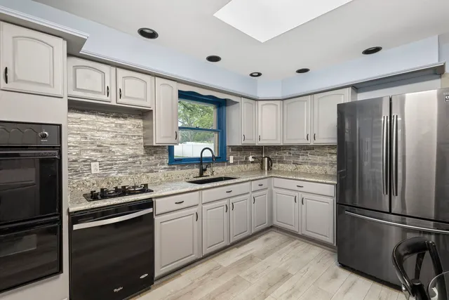 a kitchen with a sink stainless steel appliances and cabinets