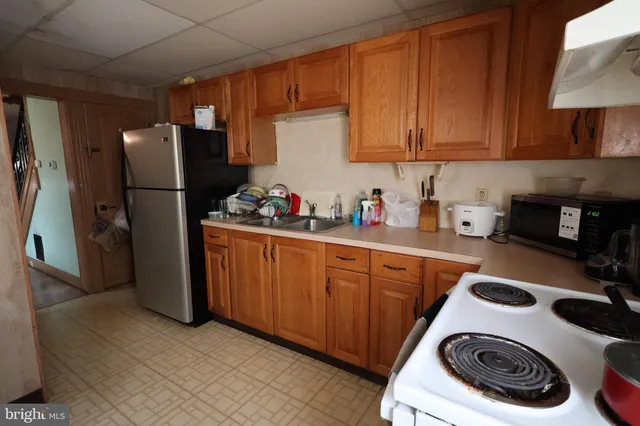 a kitchen with a refrigerator sink and cabinets