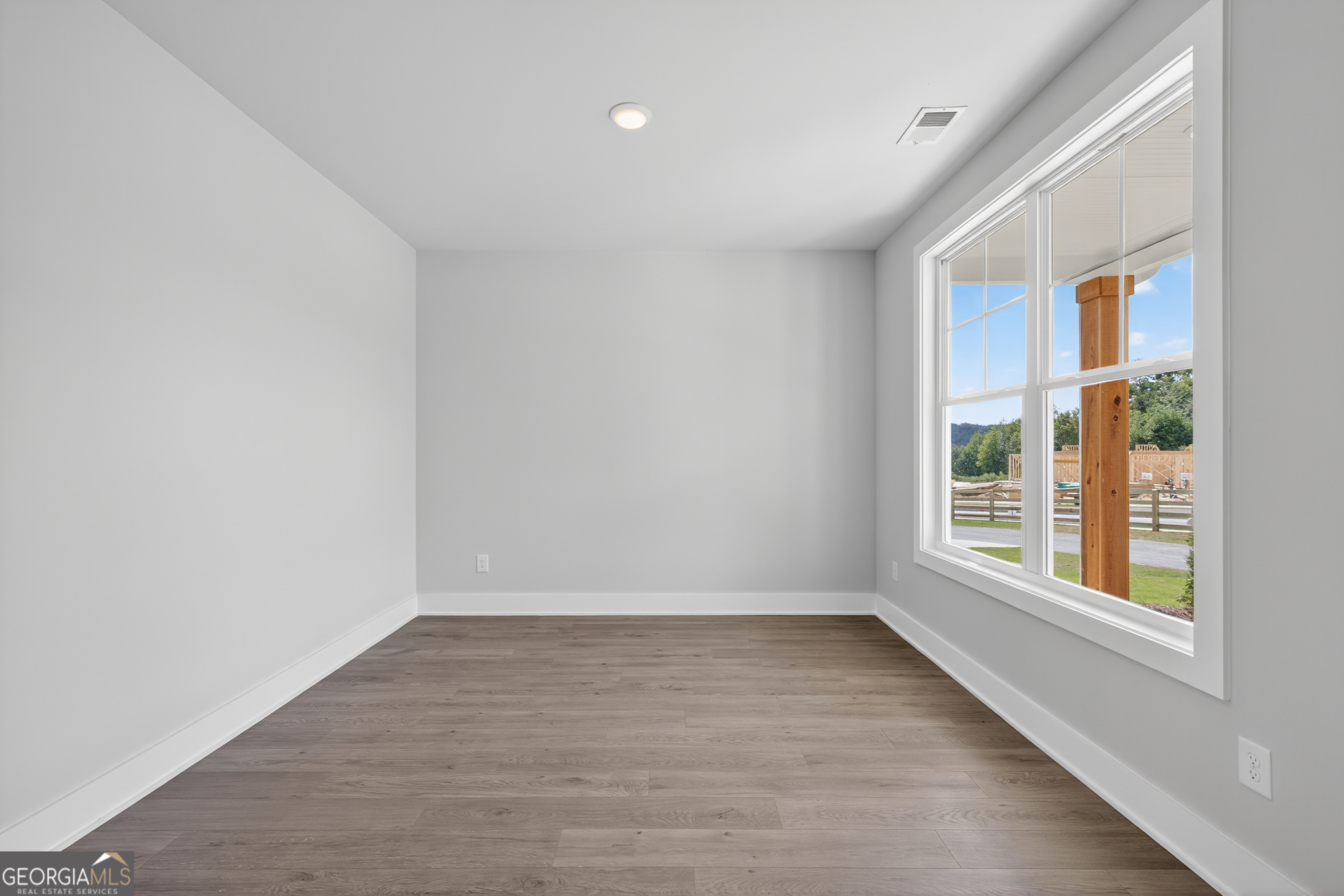 112 Patillo Manor, Unit 3 Stockbridge, GA 30281 - Photo 6 of 59 a view of an empty room with wooden floor and a window