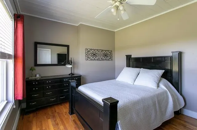 a bedroom with a bed and a flat tv screen on dresser