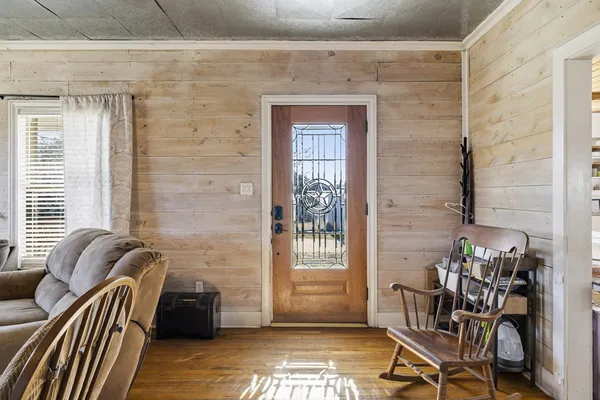 a living room with furniture a bookshelf and a wooden floor