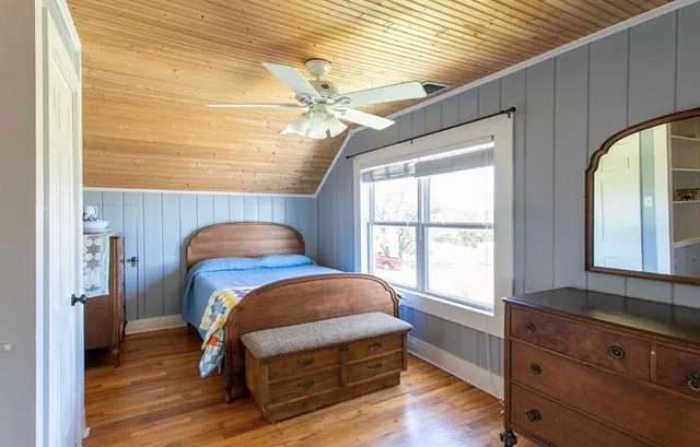 a bedroom with a bed and a large window