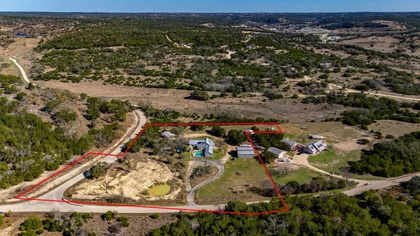 an aerial view of a house with a yard and mountain view in back