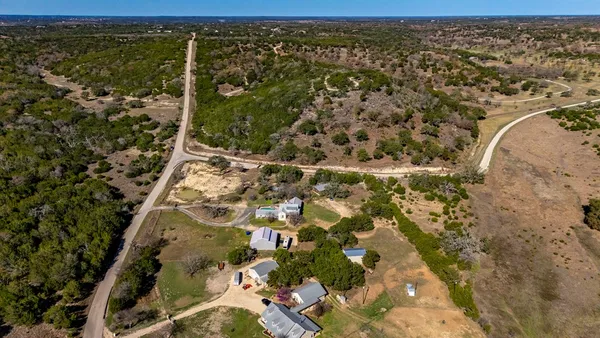 an aerial view of a house with a yard and lake view