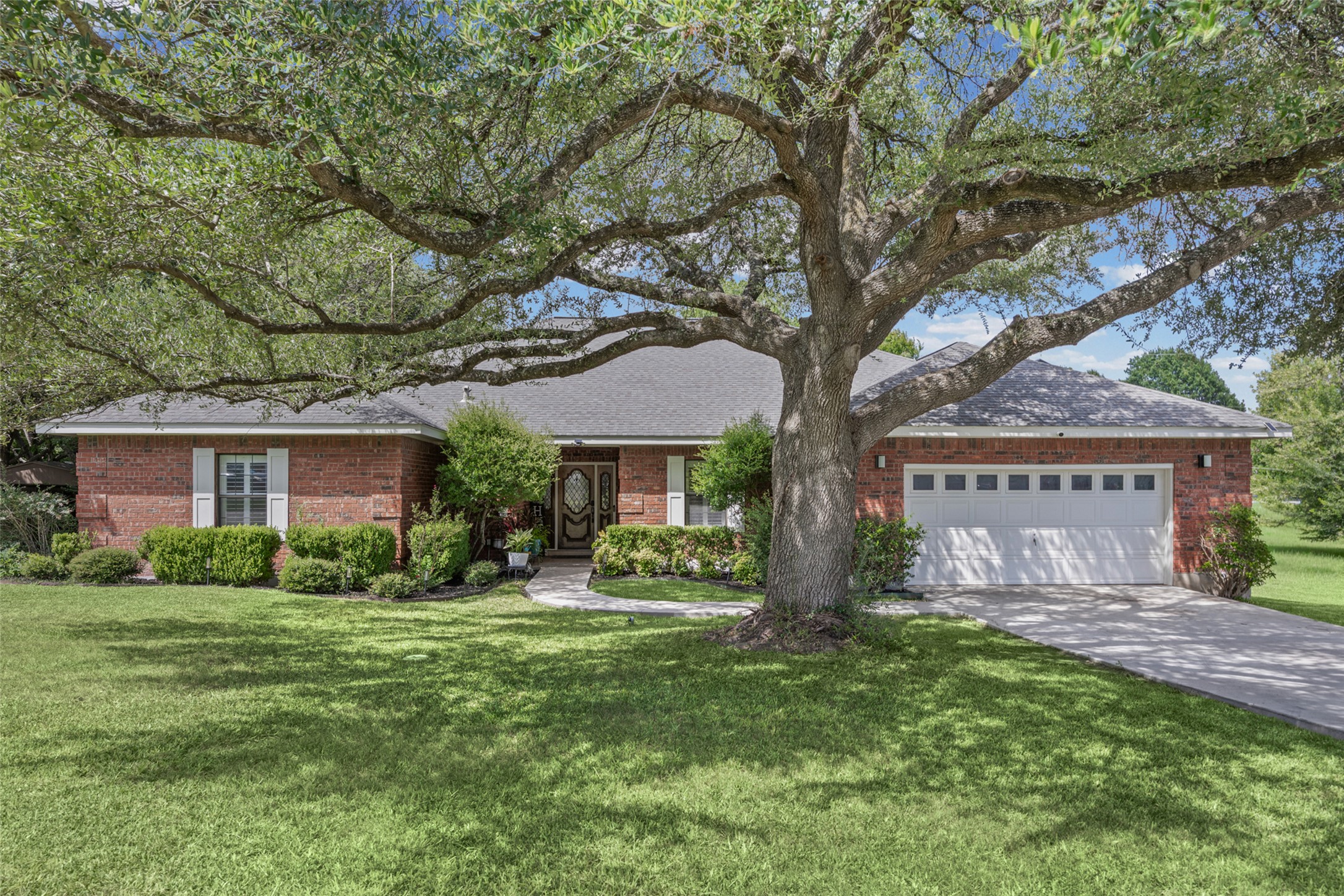 2000 Spinel Road Pflugerville, TX 78660 - Photo 1 of 31 Mature trees and lush landscaping adorn this welcoming single-story brick home with an attached garage.
