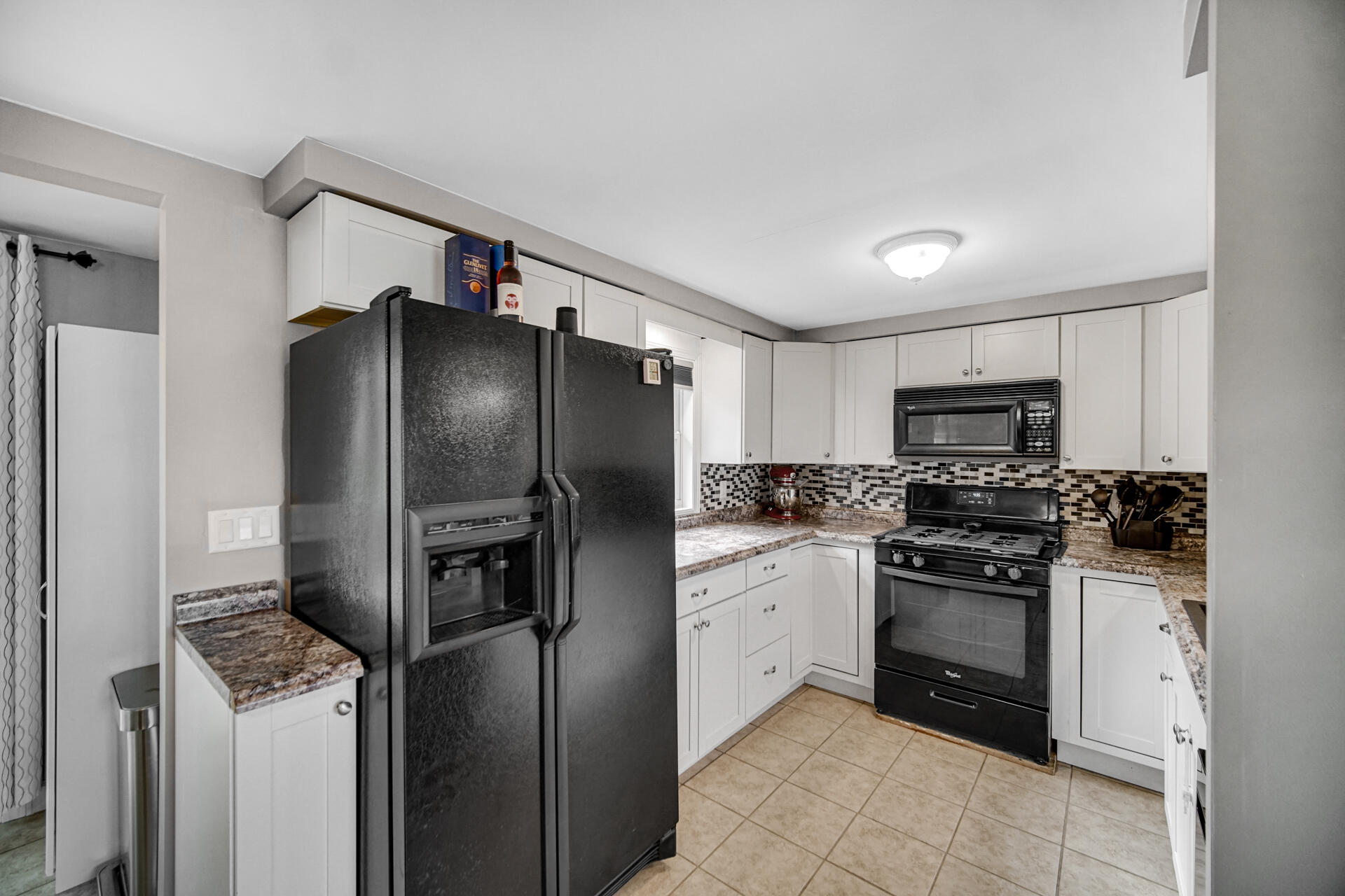 12 South Fish Lake Road Valparaiso, IN 46385 - Photo 7 of 21 a kitchen with stainless steel appliances granite countertop a refrigerator a stove and a sink
