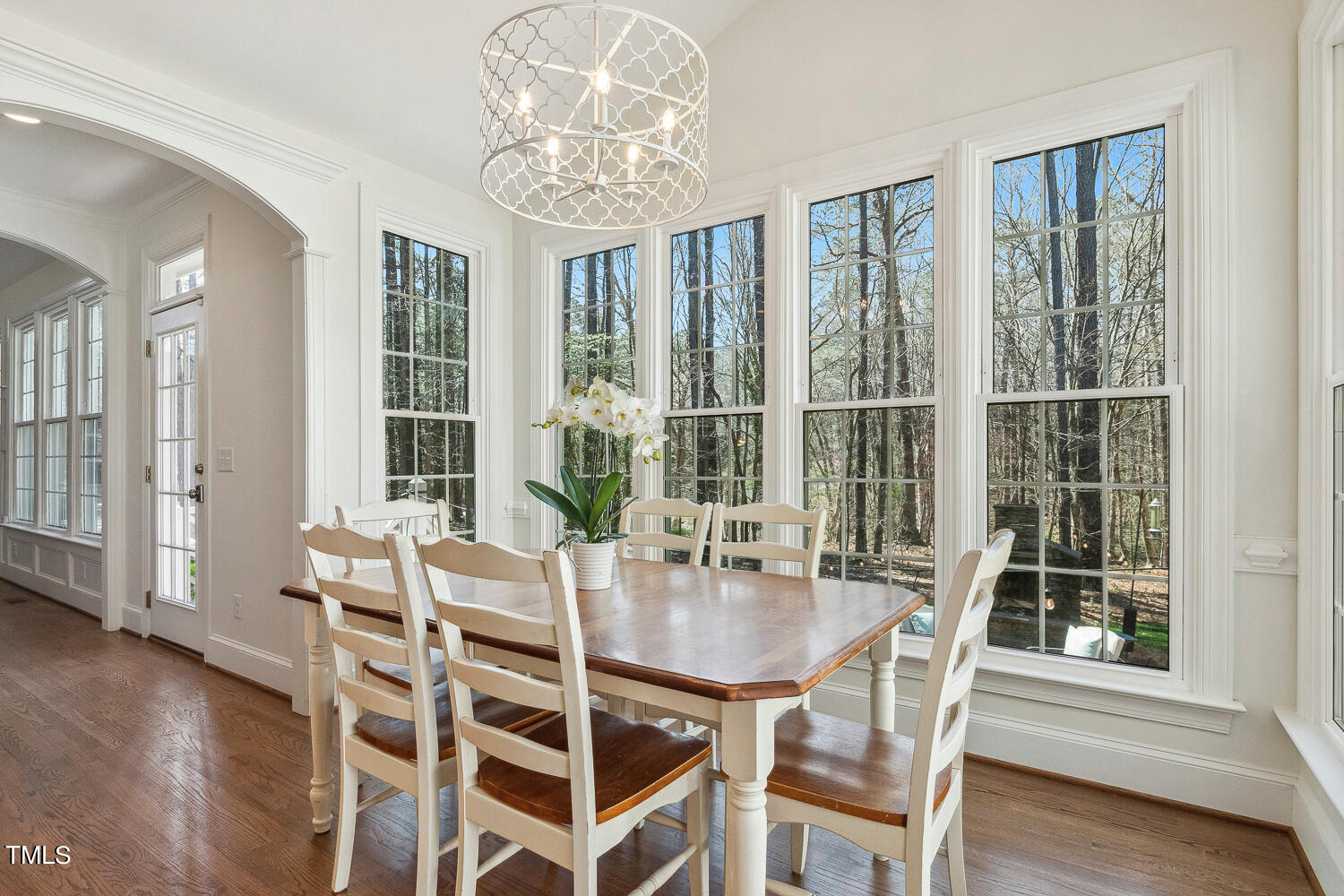 5012 Boulder Creek Lane Raleigh, NC 27613 - Photo 34 of 100 a dining room with wooden floor a chandelier a glass table and chairs
