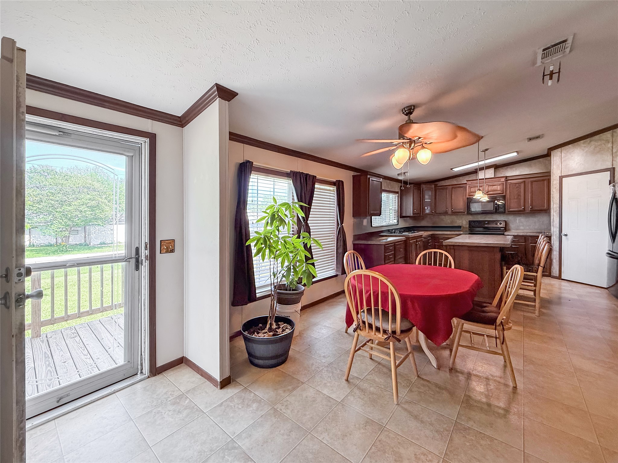 845 Caldwell Street Lexington, TX 78947 - Photo 5 of 39 Dining room featuring ornamental molding, baseboards, ceiling fan, light vinyl tile patterned floors, and a textured ceiling