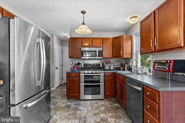 a kitchen with stainless steel appliances granite countertop a refrigerator a stove top oven a sink and dishwasher
