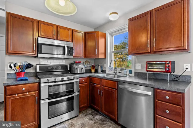 a kitchen with stainless steel appliances granite countertop a stove sink microwave and cabinets
