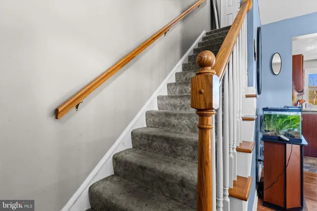 a view of a hallway with wooden floor and stairs
