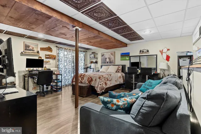 a bedroom with a bed a couch and a flat screen tv