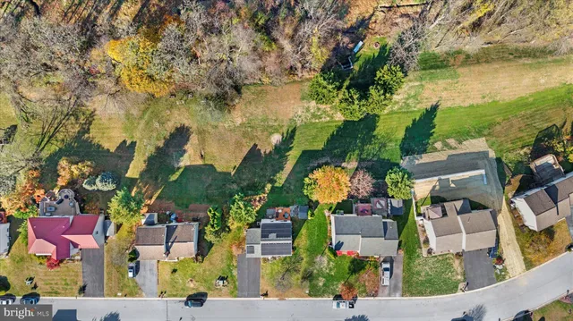 an aerial view of ocean and residential houses with outdoor space