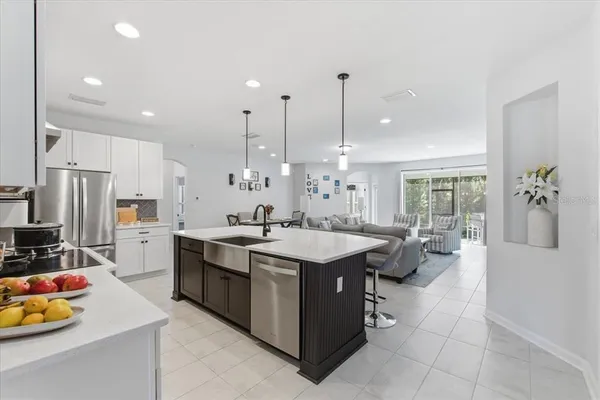 a large kitchen with kitchen island a large counter top appliances and cabinets