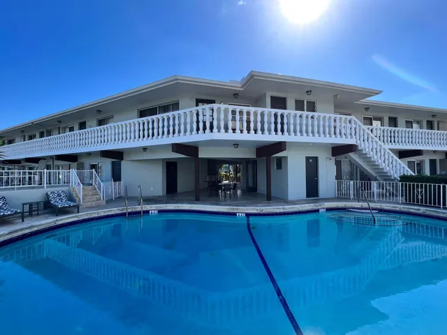 a view of a swimming pool with deck and a garden